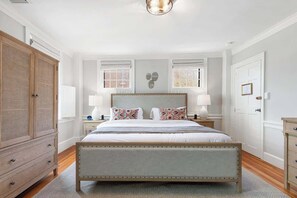 A bedroom with a large bed, wooden wardrobe, and two bedside tables with lamps. - Driftwood Suite - Luxury Retreat in Newport (Newport)
