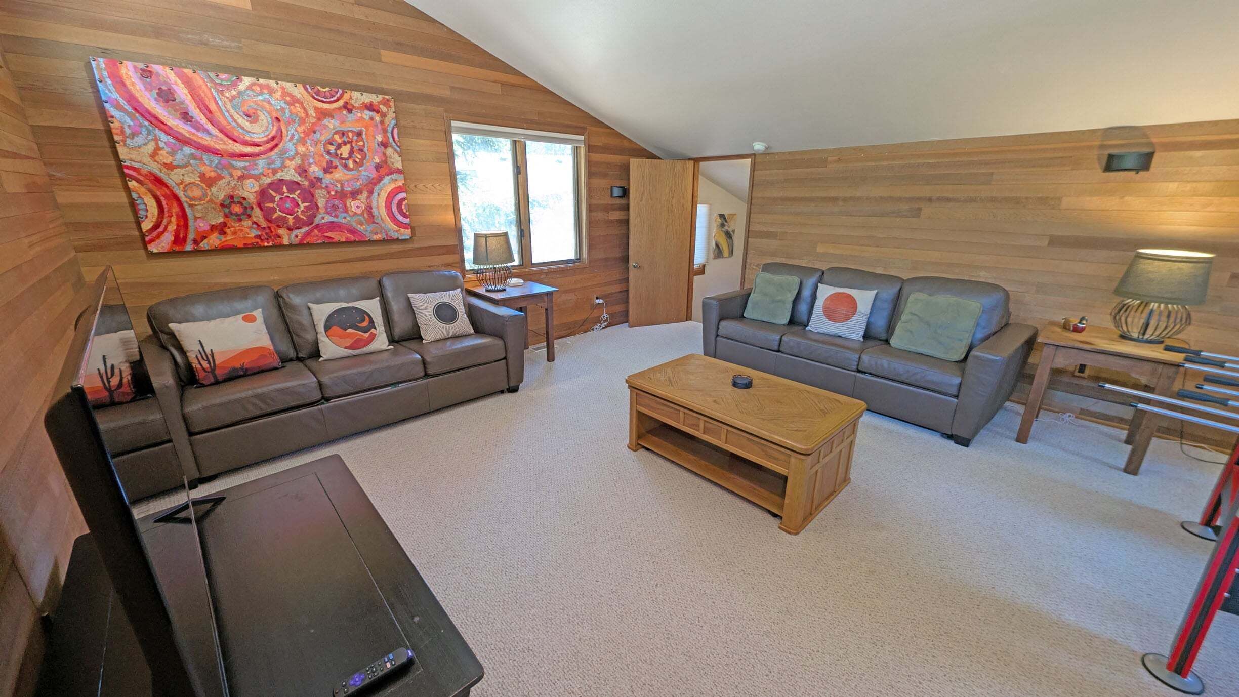 Ein Wohnzimmer mit zwei Sofas, einem Couchtisch und einem Fernseher.
