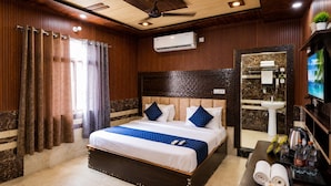 A hotel room with a bed, a TV, a sink, and a ceiling fan. - Hotel Luxury Palace Vrindavan (Vrindavan)