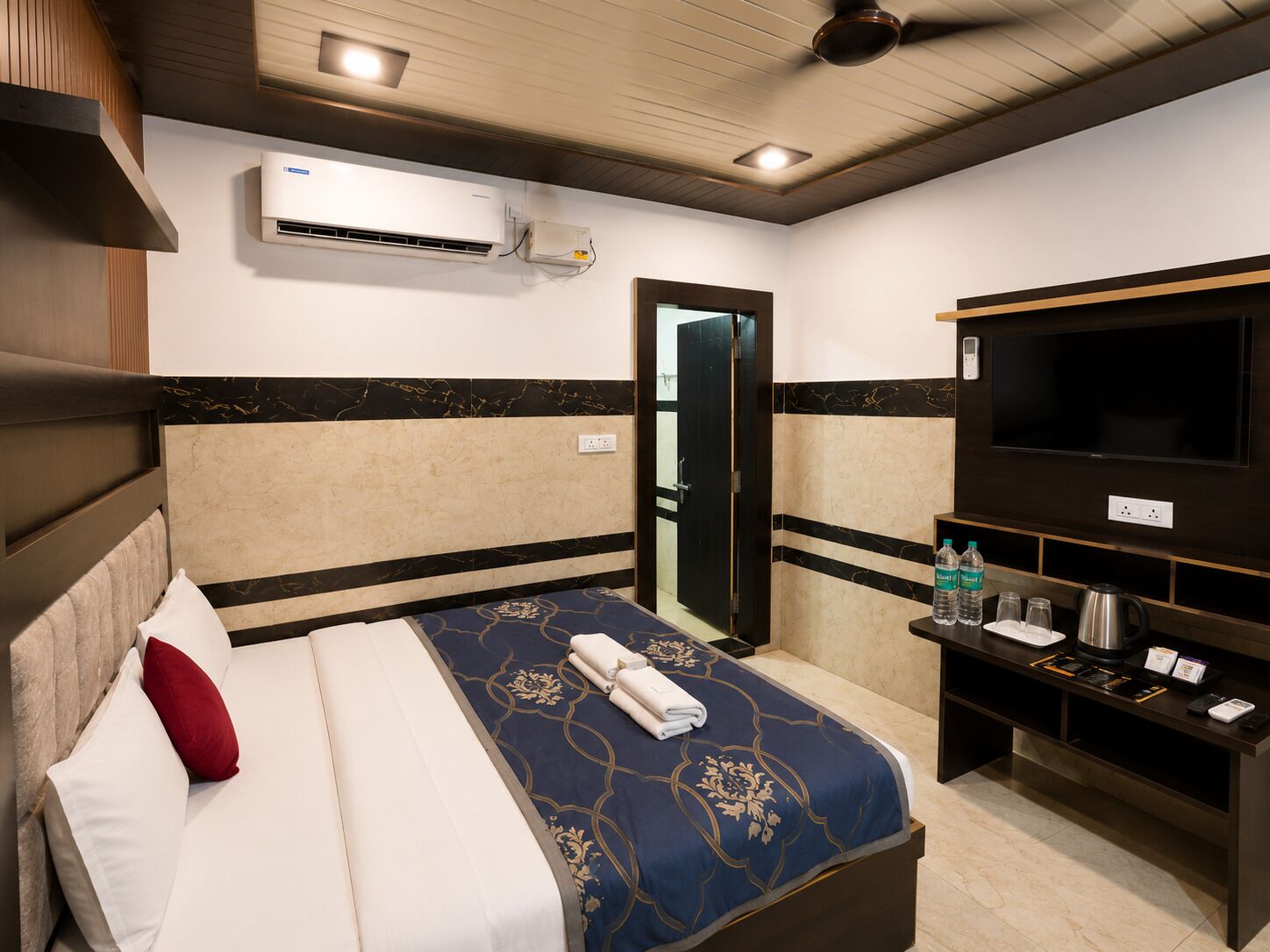 Une chambre d’hôtel équipée d’un lit, d’une télévision, d’un mini-bar et de la climatisation.