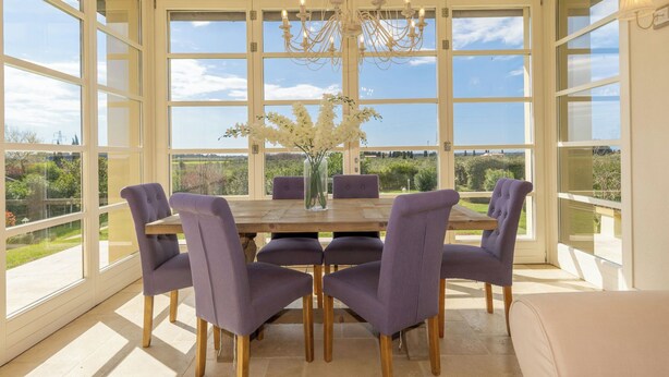 A dining area with a table, chairs, and a chandelier.