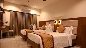 Ett hotellrum med två sängar, ett skrivbord och en stol.