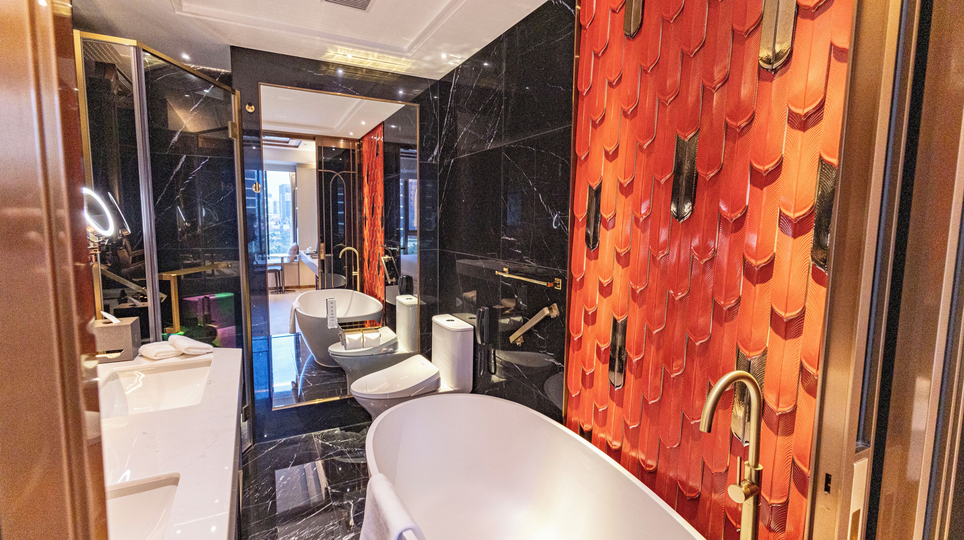 A modern bathroom with a freestanding bathtub, a vanity with a mirror, and a toilet.