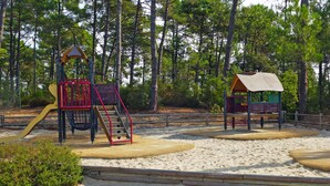 A playground with a slide, climbing structure, and a small shelter. - Les Grands Pins by Interhome (Maubuisson)