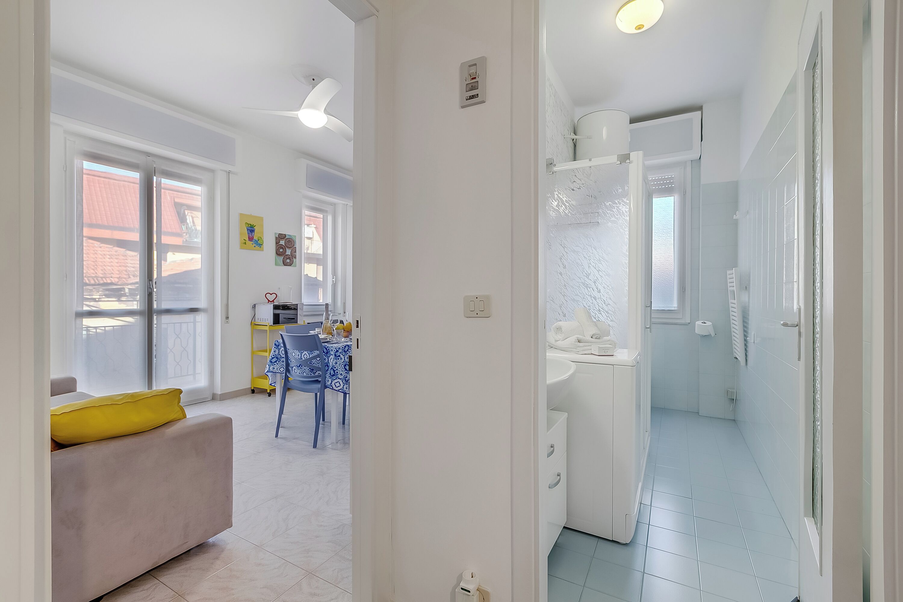 Ein Hotelzimmer mit Balkon, einem Essbereich mit Tisch und Stühlen sowie einem Badezimmer mit Waschbecken und Toilette.