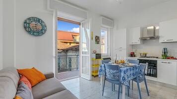 Un appartamento moderno con cucina, zona pranzo e un balcone.