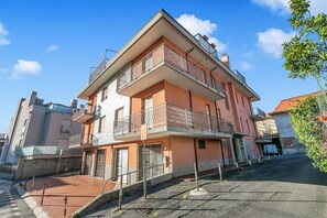 A multi-story residential building with balconies, a gated entrance, and a clear sky. - Verdi Loano Beach Apartment With Balcony (Loano)