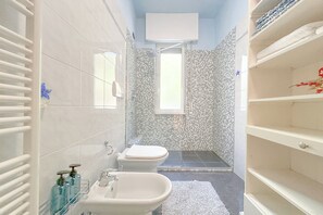 A bathroom with a shower, toilet, sink, and shelves. - SV - Mignone (Savona)