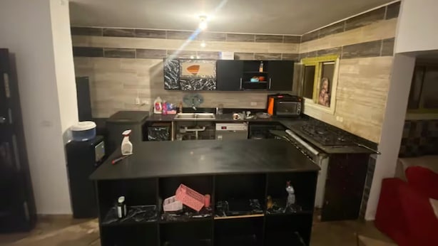 Cocina compacta con una isla central, horno empotrado y microondas.