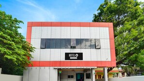 A two-story building with a sign reading "HOTEL" and a company-serviced logo. - Super Hotel O Kanyakumari Near Sunrise View (Nagercoil)