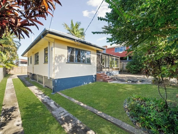 A single-story house with a front yard, a visible garage, and a small garden area.