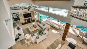 A spacious living area with a fireplace, seating, and a view of the pool. - Luxury Ghost Estate on the Noosa Sound (Noosaville)