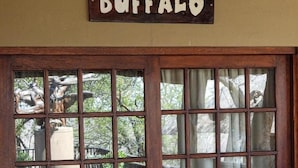 Un rètol de fusta amb la paraula “BUFFALO” sobre una finestra amb diversos vitralls.