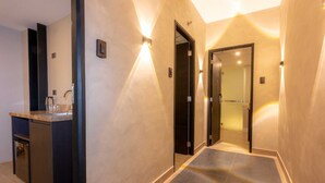 Un pasillo moderno de hotel con cocina integrada, ducha y baño.