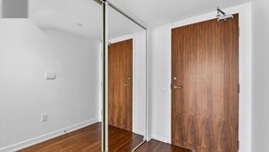 Ein Zimmer mit einer Schiebetür, Holzboden und weißen Wänden.