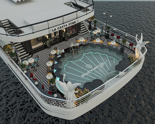 A deck with a pool, seating, and a statue. - La Casta Star Cruise (Ha Long)