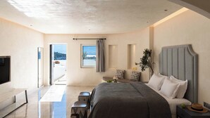 Un dormitorio moderno con una cama grande, un televisor y vistas al exterior.