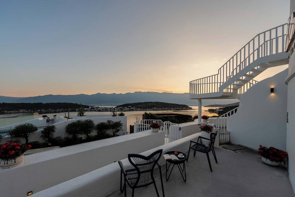 Une terrasse avec des sièges extérieurs et un escalier menant à un niveau supérieur.