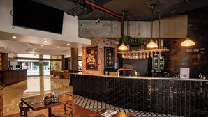 A restaurant with a bar area, wooden tables, and a patterned floor. - Inviting Brisbane Family 2BR | CBD | Pool & Gym (Brisbane City)