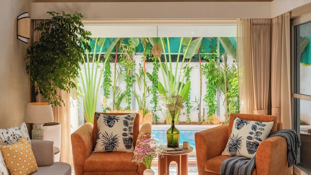 A spacious living room with two sofas, a coffee table, and a large window with a view of greenery. - TBK VILLA ASSAGAO ELEGANCE (Assagao)