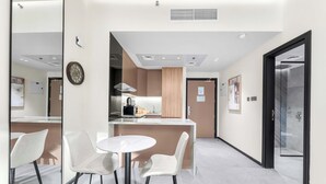Een moderne hotelkamer met een eethoek, een keuken en een badkamer.