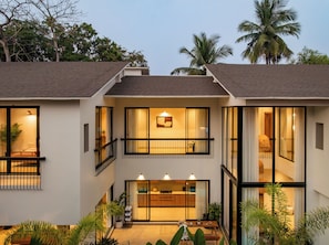 A modern two-story house with a balcony, large windows, and a well-lit interior. - TBK VILLA VAGATOR KOMOREBI 01 (Vagator)