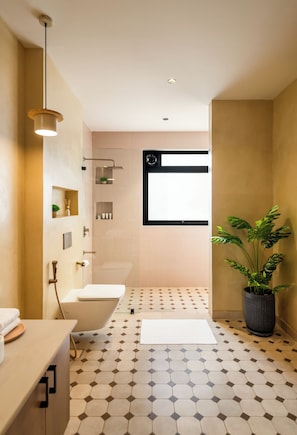 A modern bathroom with a toilet, bathtub, shower, and a potted plant. - TBK VILLA VAGATOR KOMOREBI 01 (Vagator)
