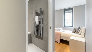 Et moderne badeværelse med indbygget håndklædestang og bruseniche.