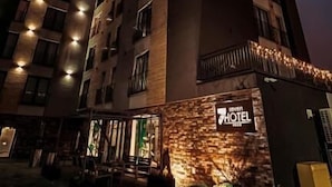 Un hôtel à plusieurs étages, doté d’une entrée imposante, d’une enseigne bien visible et d’une façade en briques.