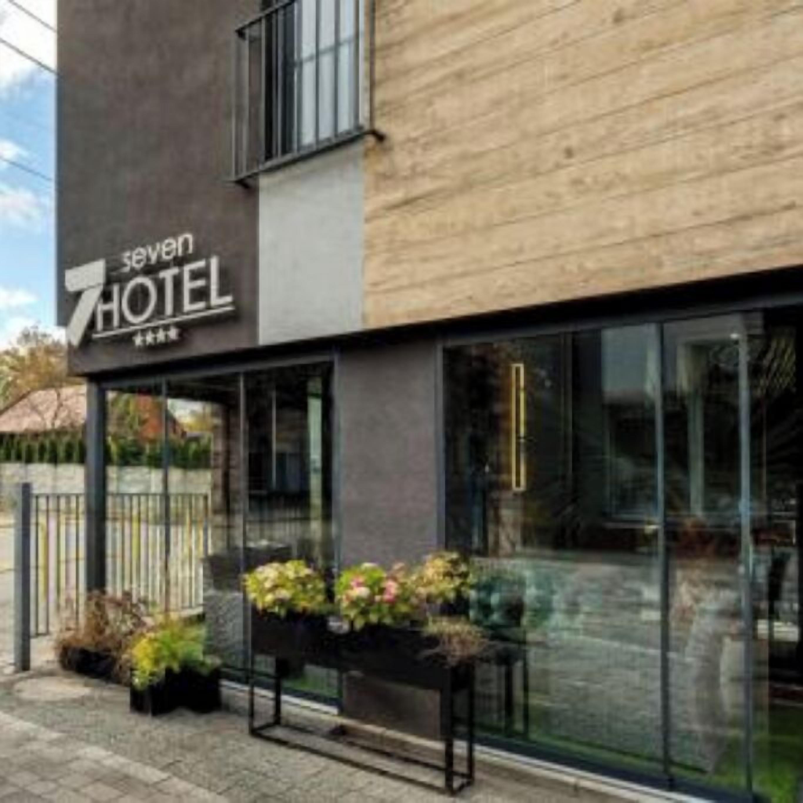 A hotel with a modern facade, large windows, and a sign that reads 'seven HOTEL'.