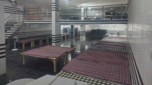 A spacious lobby with a checkered floor, a staircase, and a fan. - Shri Laddu Gopal Dham (Mathura)