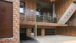 Un edificio de varios niveles con paredes de ladrillo, un balcón y un ventanal grande.