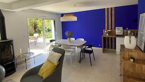 Ein modernes Wohnzimmer mit einem Glastisch, einer gelben Kissen auf dem Sofa und einer blauen Wand als Blickfang.
