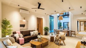 Ein modernes Wohnzimmer mit Sofa, Couchtisch und Essbereich.