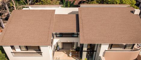 Una casa moderna de dos pisos con piscina, ventanas amplias y techo plano.