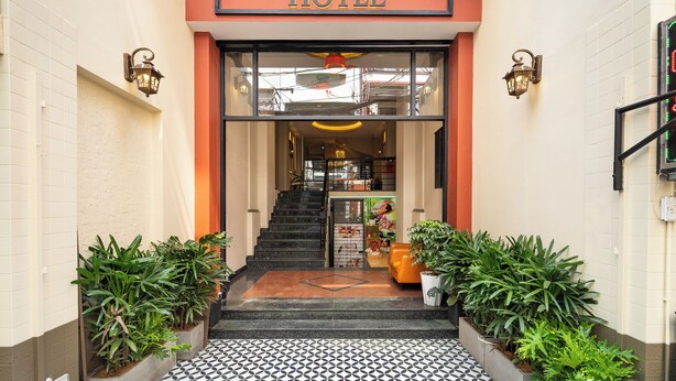 The entrance to Nicecy Hotel with a tiled floor, a staircase, and potted plants. - Nicecy Hotel - Bui Vien Central (Ho Chi Minh City)