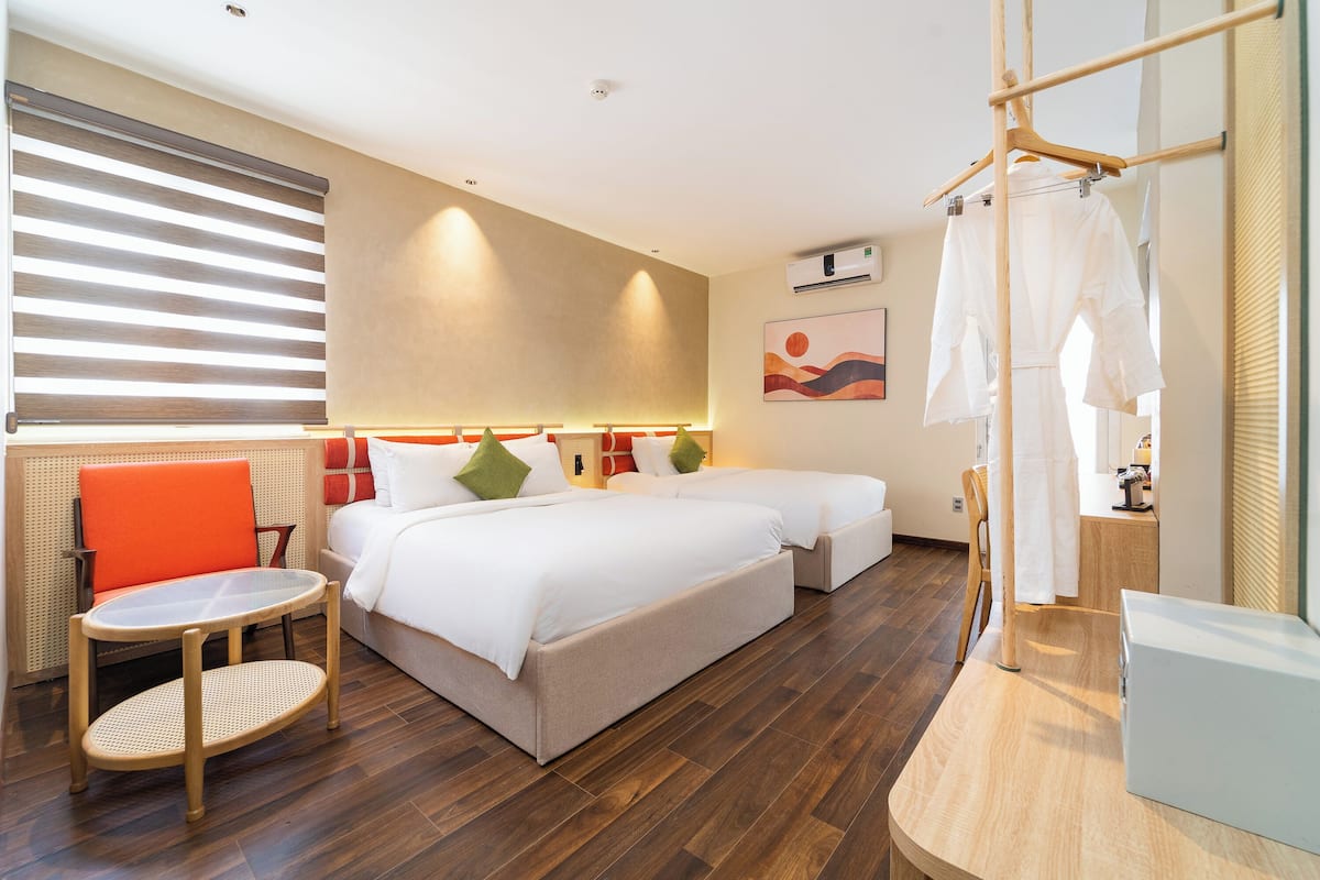 Ein Hotelzimmer mit einem großen Bett, einem kleinen Tisch, einem Sessel und einem Kleiderschrank.