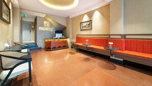 A lobby with a reception desk, seating area, and a staircase leading to another floor. - Nicecy Hotel - Bui Vien Central (Ho Chi Minh City)
