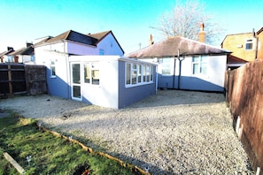 A residential property with a gravel driveway, a small garden, and a detached garage. - Large Bungalow - 3 Beds 2 Baths - Very Large Enclosed Garden - Dogs Stay Free (Birmingham)