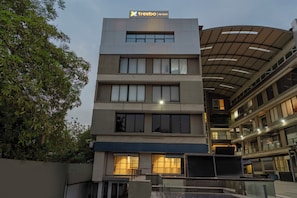 A modern multi-story building with a sign reading 'treebo | THE VELVET'. - Treebo The Velvet (Gandhinagar)