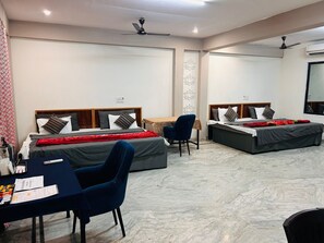 Une chambre d’hôtel avec deux lits, un bureau et une chaise.