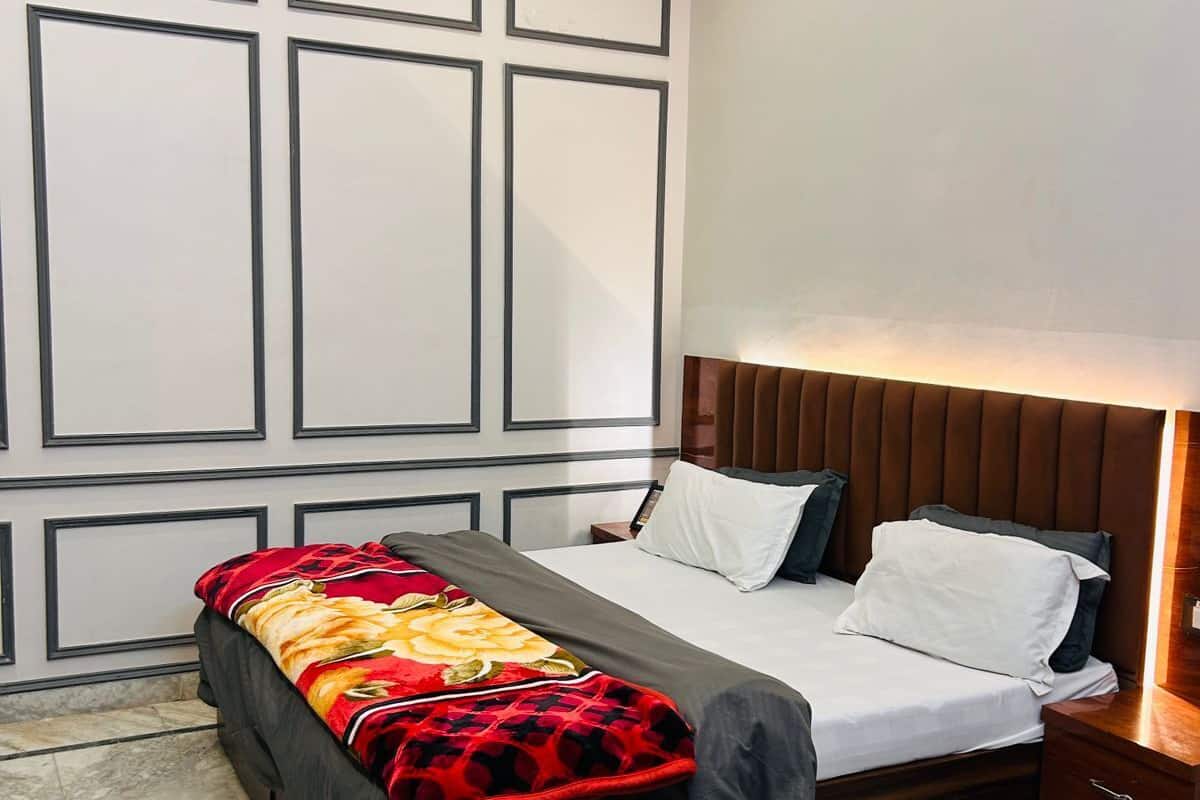 A bedroom with a bed, a bedside table, a nightstand, and a round wooden table.