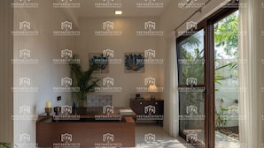 Een modern interieur met een receptiebalie, decoratieve muurkunst en een groot raam met uitzicht op groen.