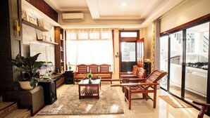 A spacious living room with a large window, a coffee table, and a sofa. - 3-bedroom villa with private pool in Bohol Philippines (Lila)