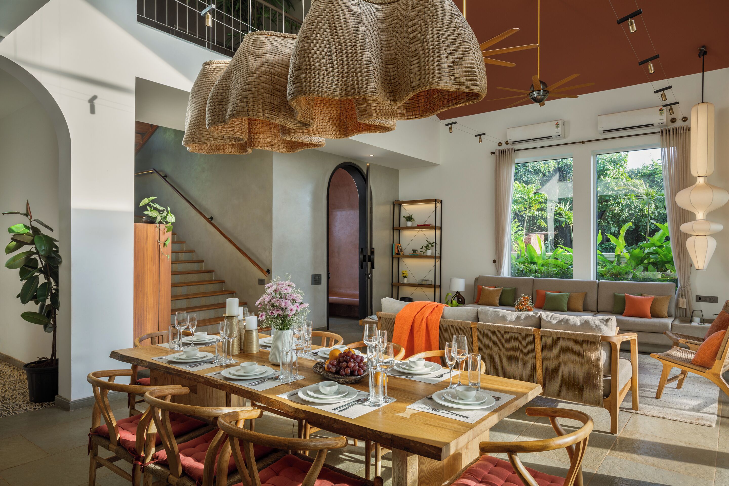 Comedor con una mesa de madera dispuesta para cuatro personas, rodeado de sillas de mimbre.