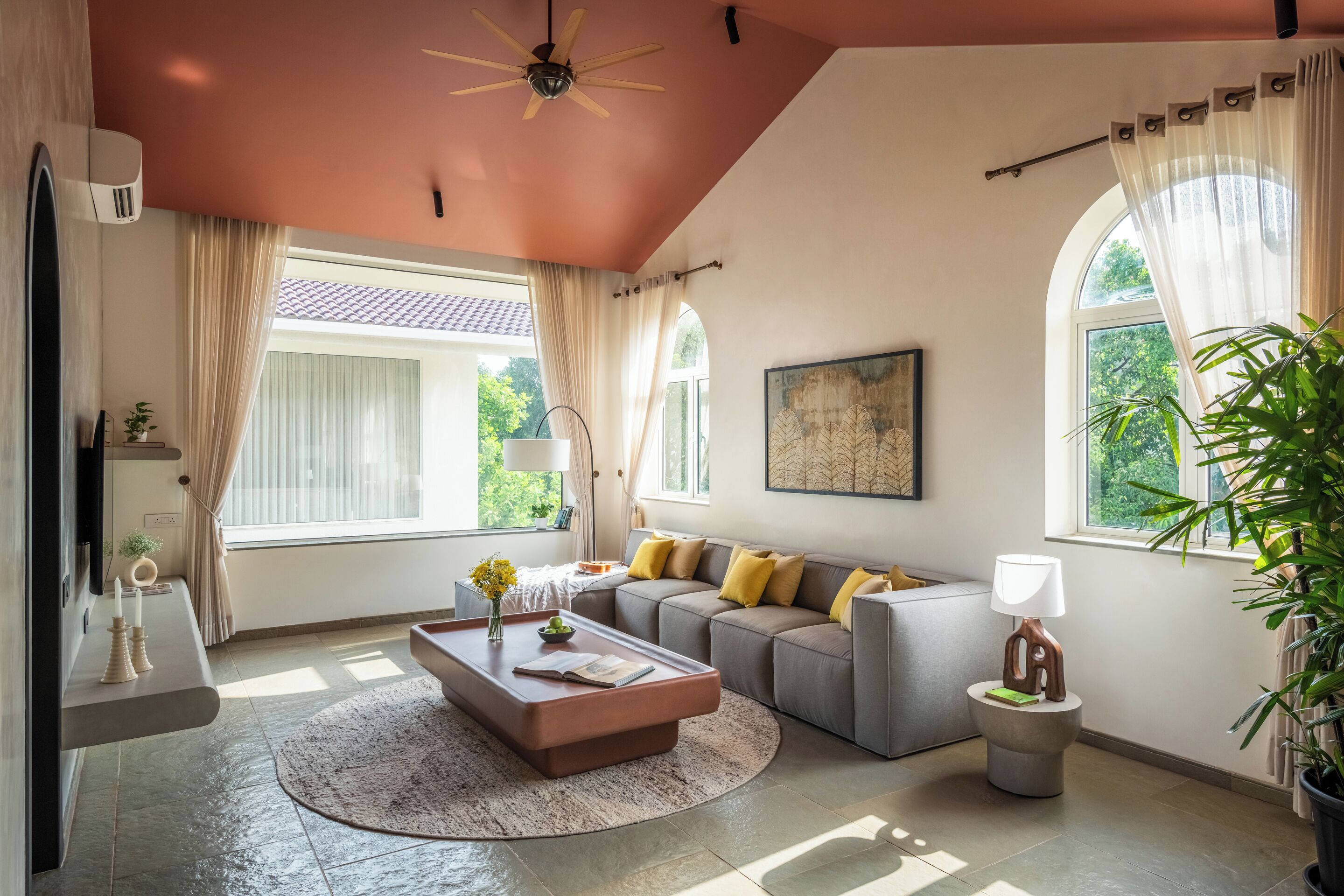 A living room with a sofa, a coffee table, a lamp, and a plant.