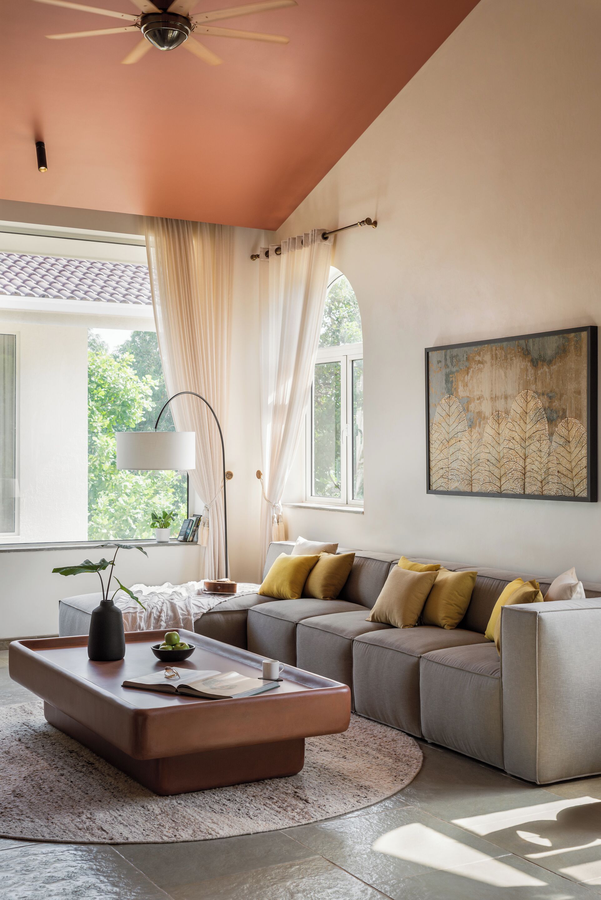 A living room with a sofa, a coffee table, a floor lamp, and a ceiling fan.