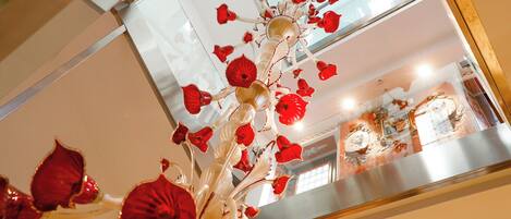 A chandelier with red and white glass flowers.