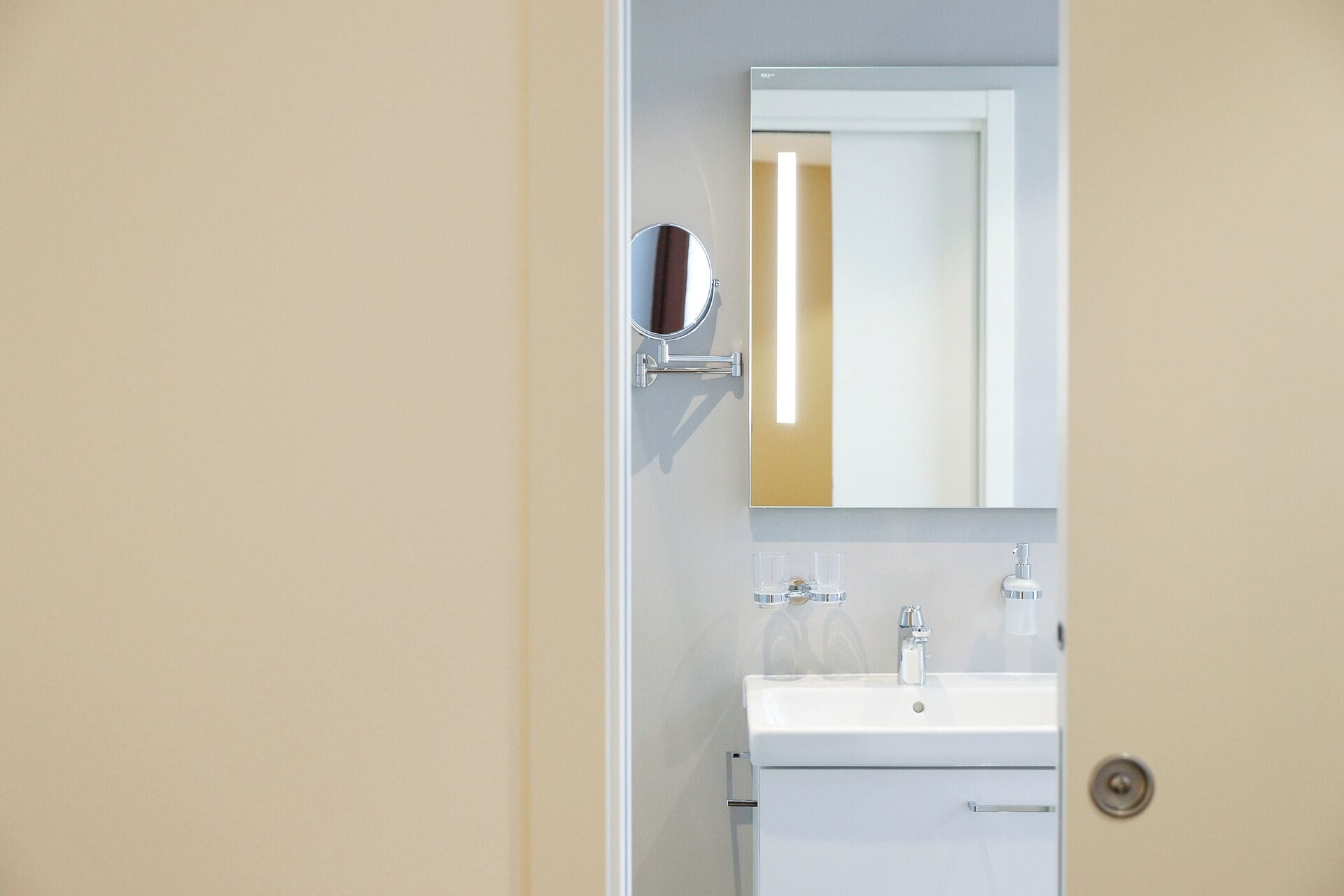 Une salle de bain avec un lavabo blanc, un miroir et des toilettes.