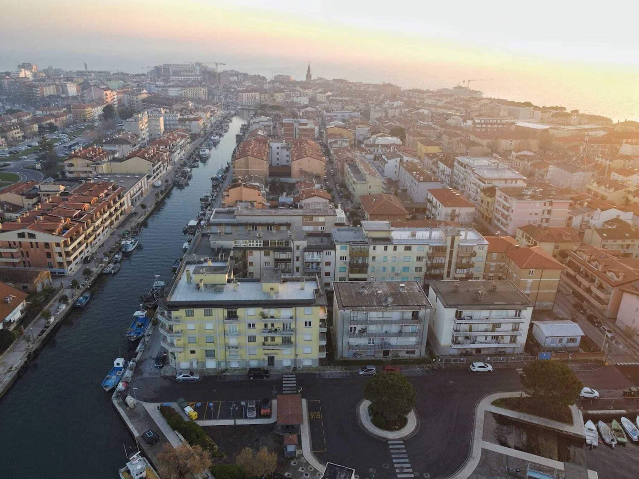Une vue aérienne d’une ville, traversée par une rivière et bordée d’immeubles à plusieurs étages dotés de balcons.